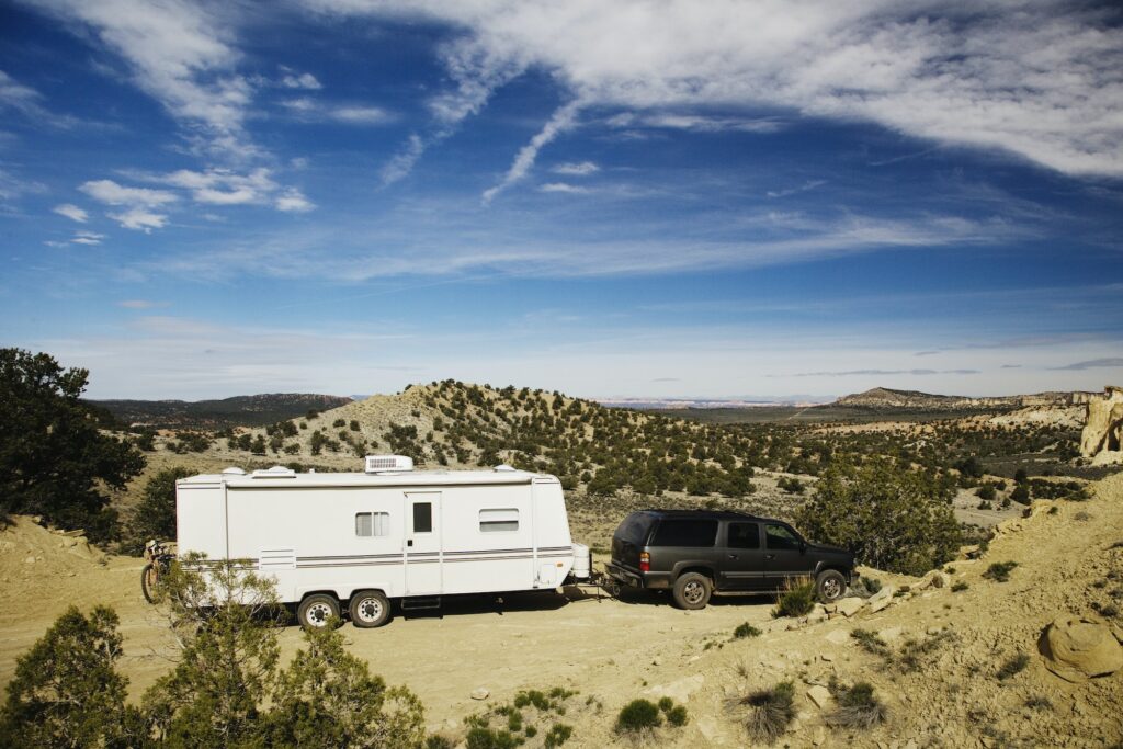 53788,Car pulling trailer in desert landscape, Grand Staircase Escalante, Utah, United States